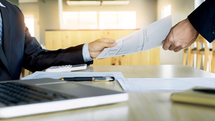 Businessman his colleague giving contract to read and sign