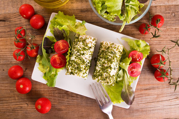 Goat cheese with salad and cherry tomatoes.