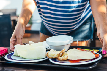 Woman holding server with breakfast