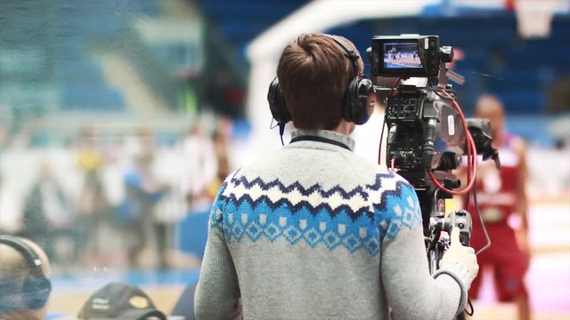 Cameraman filming at live basketball game