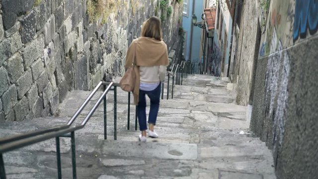 Woman walking down on stairs in city
