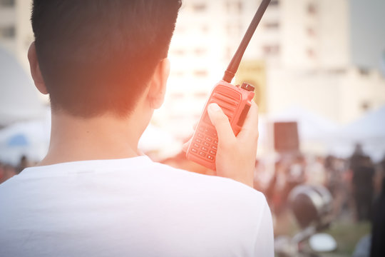 Man with a Walkie Talkie or Portable radio transceiver for communication at event