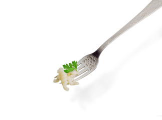 Cooked spiral pasta on the fork on a light background
