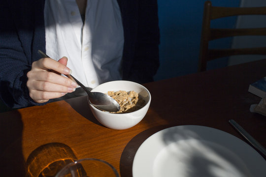 hand of woman eating cornflakes