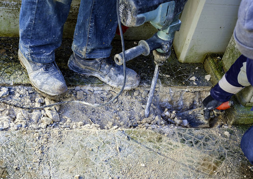 Workers perform small excavation work with tools during new fiber optic construction work. closeup with blurred motion