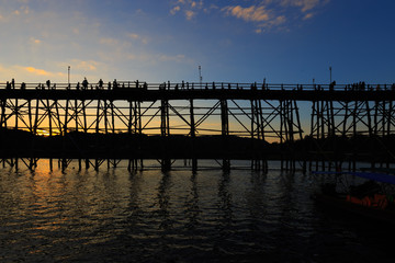 Obraz premium The old wooden bridge Bridge collapse Bridge across the river and Wood bridge (Mon bridge) during the sunset at sangklaburi, kanchanaburi, Province Asia thailand