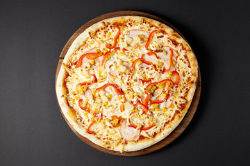 Hot pizza Hawaii on a rustic wooden table.