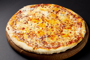 Hot pizza Quattro Formaggi on a rustic wooden table.