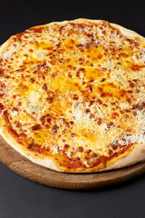 Hot pizza Quattro Formaggi on a rustic wooden table.