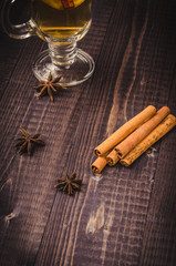 cinnamon, anise and orange with hot tea on a woodn background/Hot mulled tea with cinnamon, orange and anise