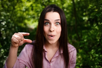 Portrait of mocking or extremely surprised  of something small woman with wide-eyed face, showing...