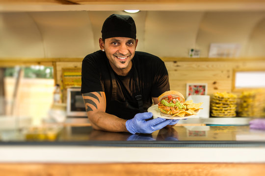 Smiling vendor with burger