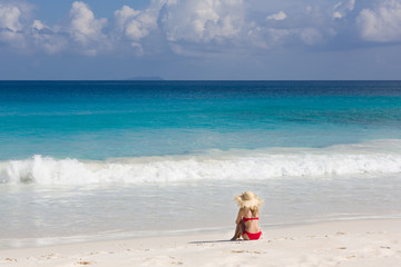 Fototapeta na wymiar Colorful ocean beach, slim woman in red swimsuit and straw sun hat