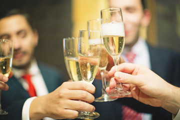 Hand sholding glass of champagne at party. Celebration concept