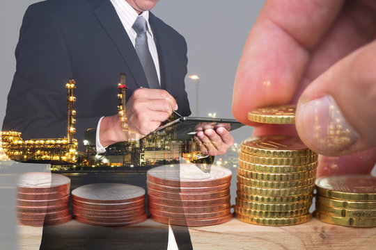Double exposure of Euro Coin stacks on table, businessman working with tablet and oil refinery industry plant in the night as business, investment,currency, exchange rate and energy concept.