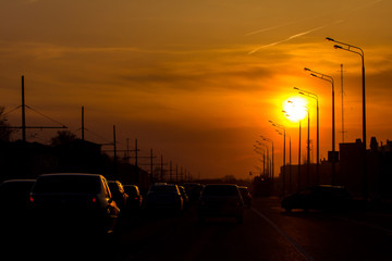 Car traffic against the sunset background - modern city - silhouette