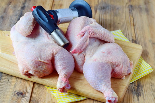 Two halves of raw chicken with flamber on a wooden cutting board. Cooking step by step. Healthy eating concept