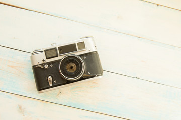 Old retro camera on light blue background. Copy space