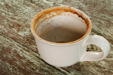 Dirty cup after drinking coffee on old wood table.