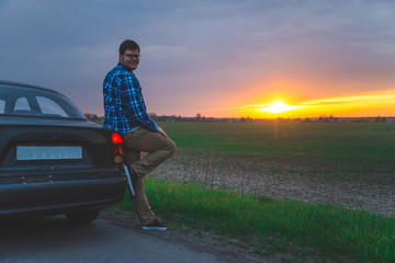 Fototapeta premium car trip man stops to look sunrice on the highway