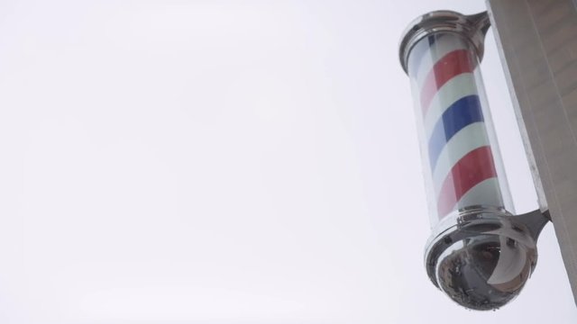 A classic barber pole set against a clouded sky background that is perfect as copy-space.