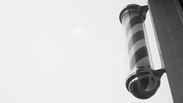 A classic barber pole set against a clouded sky background that is perfect as copy-space.