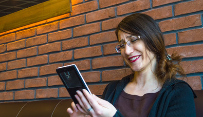 Young happy woman with long hair enjoying her smartphone