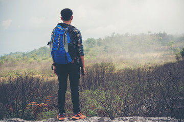 Obraz premium Hiker with backpacks standing on top of a mountain and enjoying nature view.