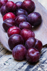 Violette Pflaumen auf einer Holzschaufel
