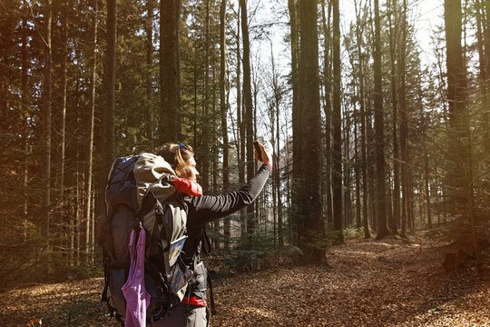 Woman taking a selfie on a hike through the woods