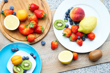 Obraz na płótnie Canvas Obs at the wooden table, lemon, kiwi, strawberries, peach