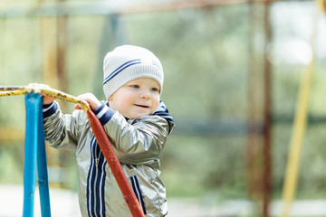 Little boy riding a swing in park playground
