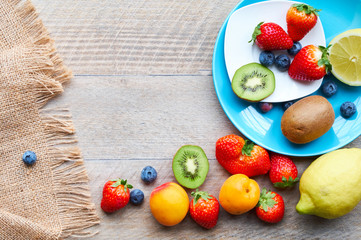 Obs at the wooden table, lemon, kiwi, strawberries, peach