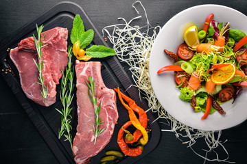 Salad with salmon and steak meat. Italian cuisine. Top view. On Wooden background.