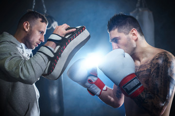 Male boxer sparring with personal trainer