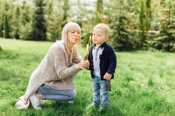 Little boy do bubbles with his mother at park