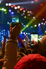 People holding their smartphones and photographing concert