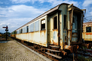 Fototapeta na wymiar rusty old railcars and trains on an abandoned rail platform