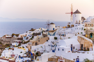 Fototapeta premium Malowniczy widok na Stare Miasto Oia na wyspie Santorini, białe domy, wiatraki i kościół z niebieskimi kopułami, Grecja