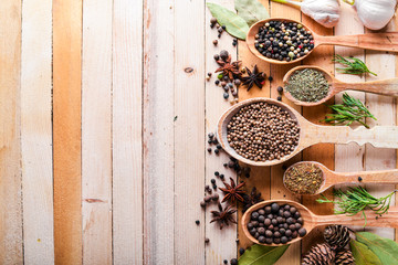 A set of fragrant spices. A mixture of black and red pepper, coriander, paprika. On Wooden background. Top view. Free space.