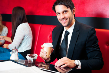 Businessman Sitting In A Cafe, Working On His Tablet