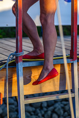 Beine mit roten Pumps an Leiter am Steg © C@rsten