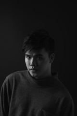 Young asian man's portrait against black background