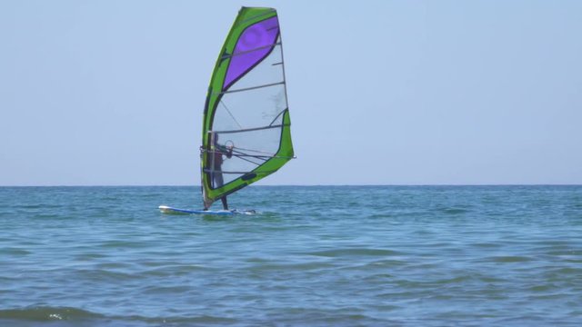 People learn windsurfing on the Baltic Sea in Zelenogradsk. In the background a dry cargo ship.