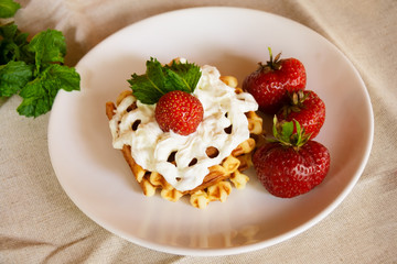 Waffles with whipped cream and strawberries. Selective focus