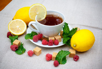 Tea with mint, brown sugar, raspberry and lemon on  table