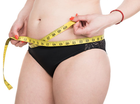 Overweight woman measuring waistline
