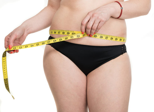 Overweight woman measuring waistline