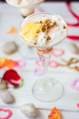 Ice cream dessert on table with hearts, ribbons and cloves.