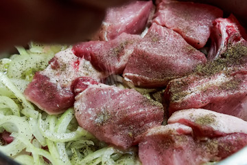 Close up raw pork with onions in pan